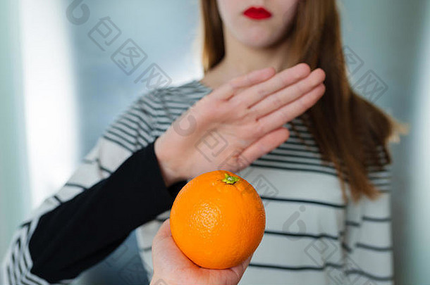柑橘类水果过敏概念食物不宽容年轻的女孩拒绝吃橙色浅深度场