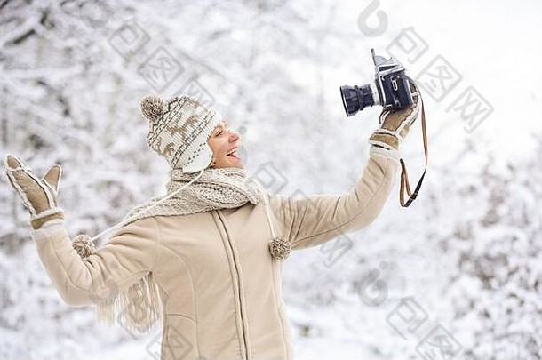 准备好了天气预测探险冬天女孩古董相机快乐女人使自拍相机冬天自拍有趣的户外雪森林冷天气带来了好情绪