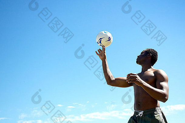 非洲男人。玩足球海滩