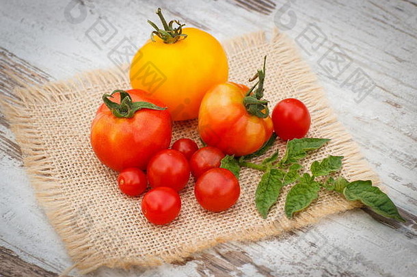 新鲜的西红柿绿色叶子黄麻帆布白色木表格花园阳光明媚的一天健康的营养