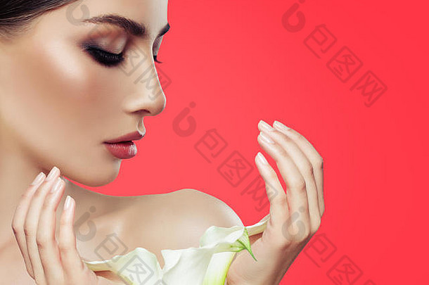 特写镜头肖像完美的女脸女人健康的皮肤修剪整齐的手白色花