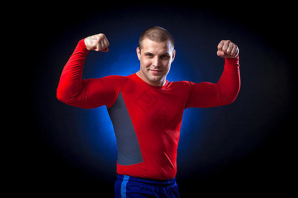 强大的黑头发的sportman红色的体育穿冲警卫显示肱二头肌蓝色的灯黑色的孤立的背景