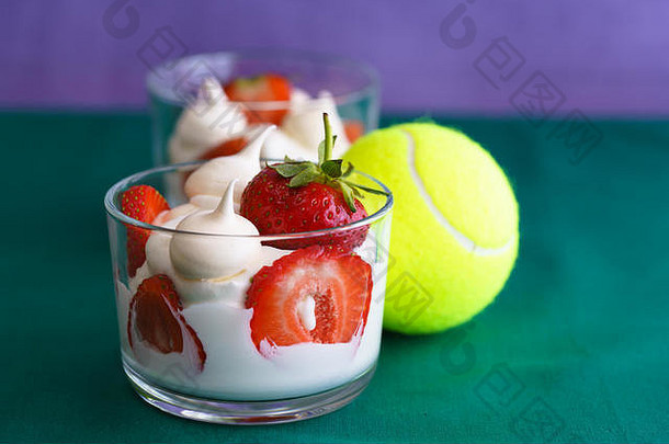 温布尔登<strong>网球公开赛</strong>启发生奶油蛋白派新鲜的草莓玻璃碗绿色紫罗兰色的背景<strong>网球</strong>球