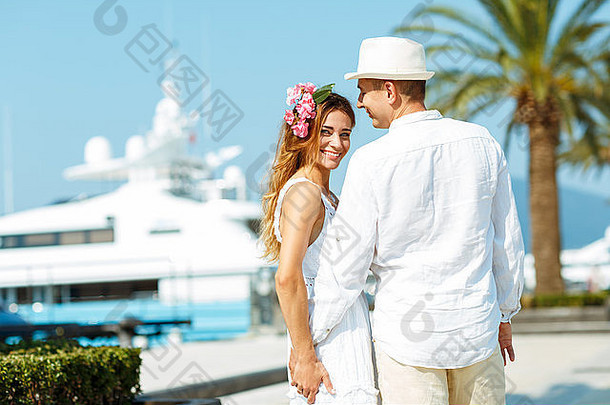 有吸引力的年轻的夫妇走与玛丽娜停泊船奢侈品海滨夏天阳光婚礼re