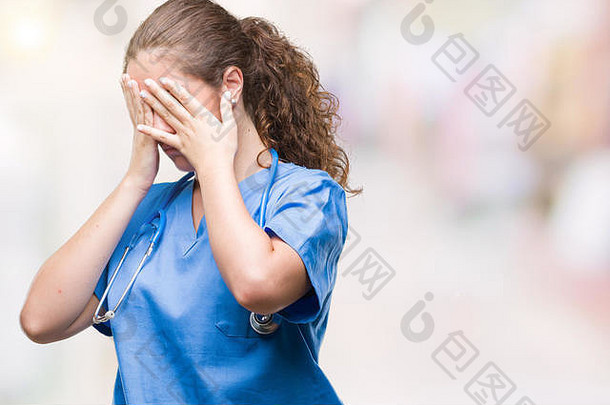 年轻的浅黑肤色的女人医生女孩穿护士外科医生统一的孤立的背景伤心表达式覆盖脸手哭着