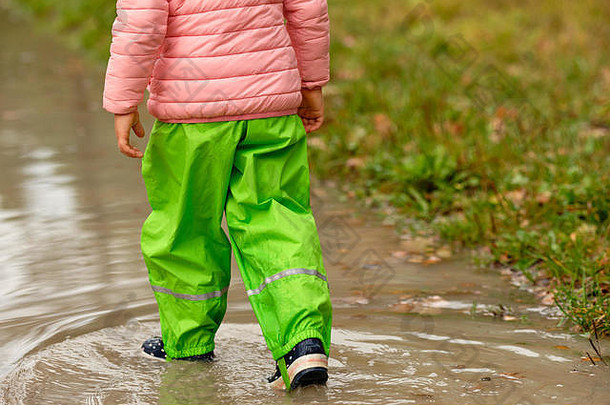 低部分孩子女孩绿色防水<strong>裤子</strong>橡胶靴子走巨大的雨水坑森林多雨的秋天一天octob