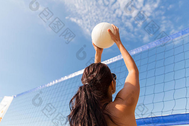 年轻的女人球玩排球海滩