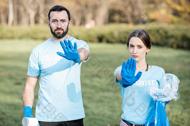 肖像男人。女人志愿者蓝色的t恤垃圾袋显示停止手担心环境