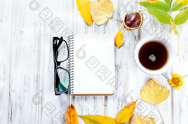 秋天生活杯茶饼干空笔记本镜片叶子白色木背景概念秋天舒适的情绪