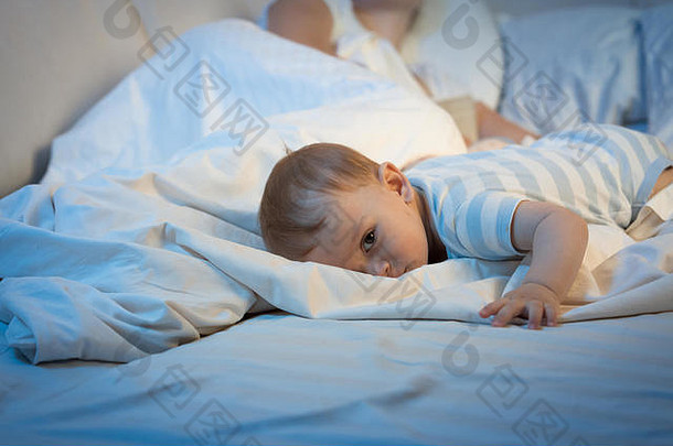 肖像累了婴儿男孩说谎大床上晚上相机
