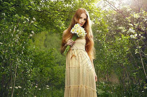 肖像美丽的年轻的女人花花园