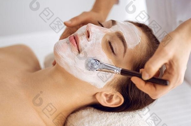 美丽的浅黑肤色的女人女人享受应用化妆品面具关闭眼睛放松治疗医学水疗中心中心概念