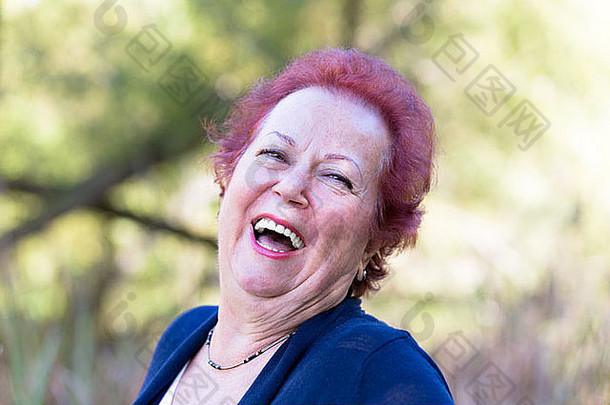 红色的头发热情的高级女人给真正的笑
