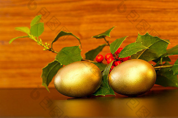 黄金巢鸡蛋节日绿色冬青嫩枝红色的浆果木粮食背景