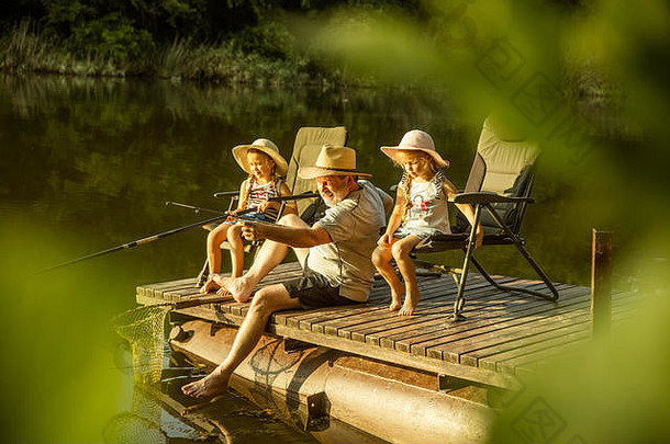 可爱的女孩爷爷钓鱼湖河休息码头水森林日落时间夏天一天概念家庭娱乐童年自然