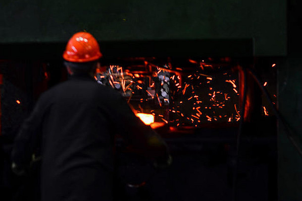 热铁冶炼厂举行工人重行业冶金植物火花炉子metall打造铁匠背景飞行火花