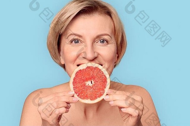 成熟的岁的女持有片柑橘类口