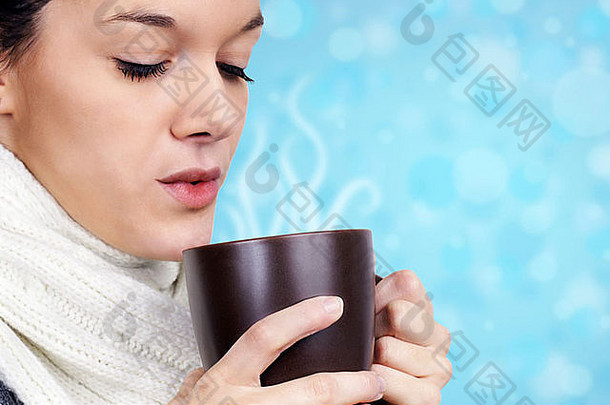 年轻的女人喝热饮料冷冬天一天