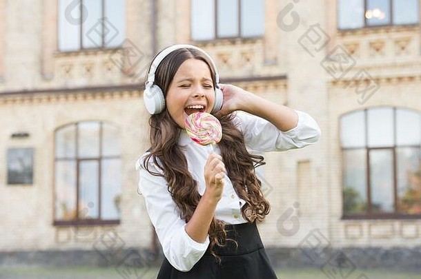 明星女孩耳机女孩优雅的统一的吃棒棒糖回来学校现代教育技术孩子校园想象一下歌手孩子音乐打破