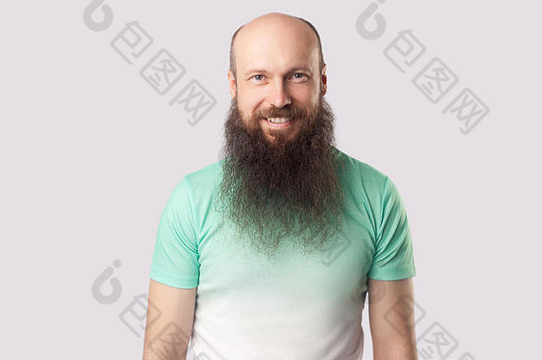 肖像快乐满意中间岁的秃男人。长胡子光绿色t恤站相机露出牙齿的微笑室内以某