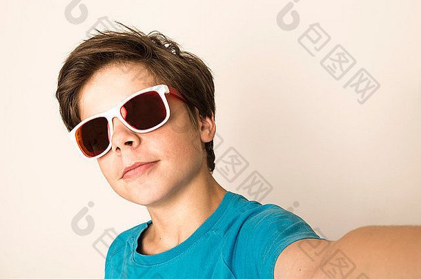 快乐年轻的男孩太阳镜自拍智能手机首页孤立的白色背景