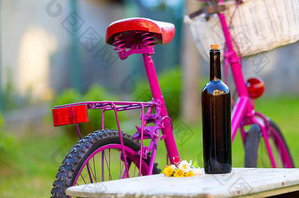 瓶红色的酒粉红色的自行车白色篮子野餐场景<strong>绿色</strong>草
