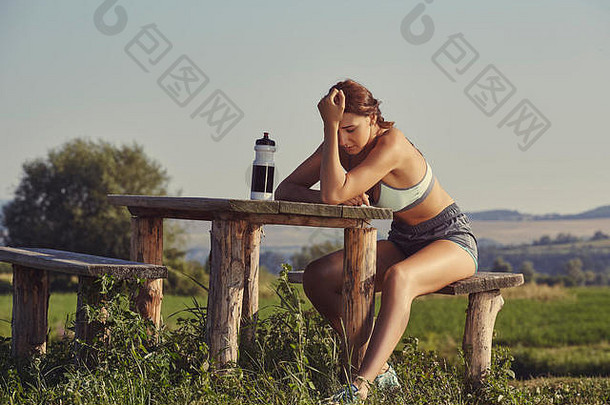 疲惫女跑步者手头休息乡村木板凳上漂亮的年轻的女人头疼dehydratio