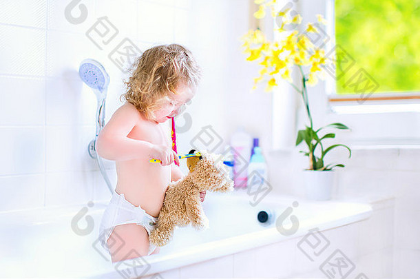 快乐有趣<strong>的</strong>婴儿女孩穿尿布刷牙牙齿玩泰迪熊玩具牙刷浴缸
