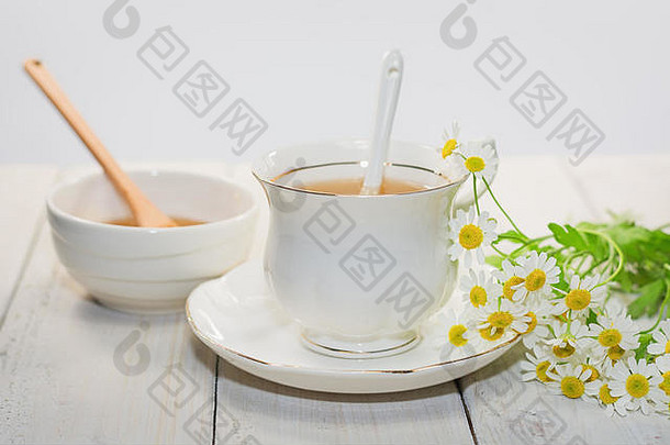 碗填满花蜂蜜勺子杯茶装饰洋甘菊