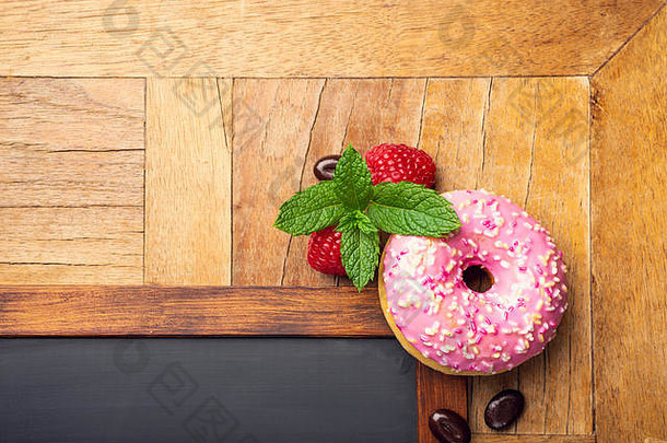 黑色的黑板粉红色的上釉甜甜圈