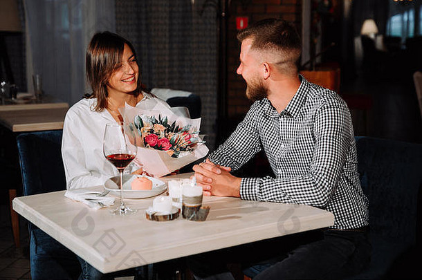 有吸引力的年轻的女人花的男朋友坐着咖啡馆