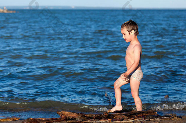 快乐的快乐男孩走有趣的海滩弄脏的沙子孩子家庭概念