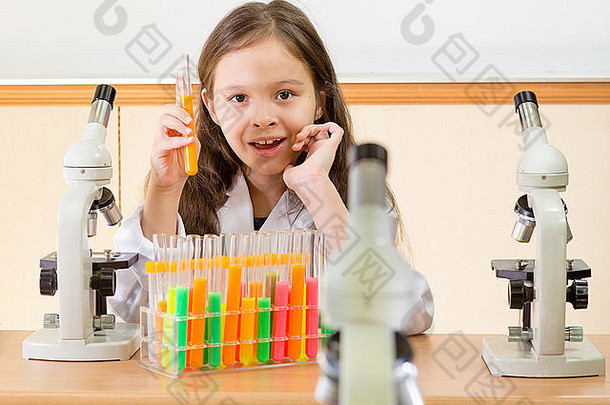 年轻的女孩科学家显微镜持有测试管科学实验室