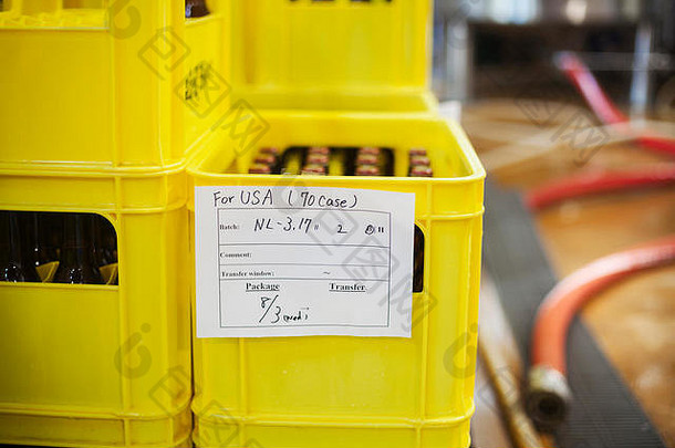 关闭黄色的塑料箱啤酒瓶手写的标签