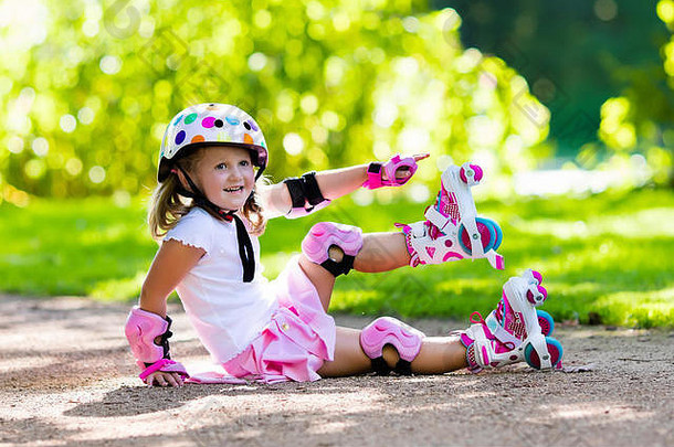 女孩<strong>学习</strong>辊滑冰阳光明媚的夏天公园孩子穿保护肘膝盖垫手腕警卫安全头盔安全角色