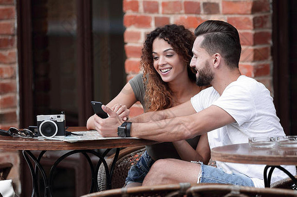 肖像年轻的夫妇坐着咖啡馆阳台