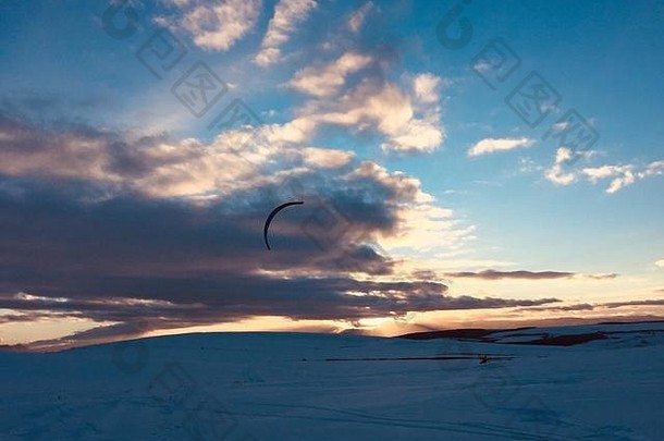 女人snowkiting山日落有趣的冬天活动冻结冷