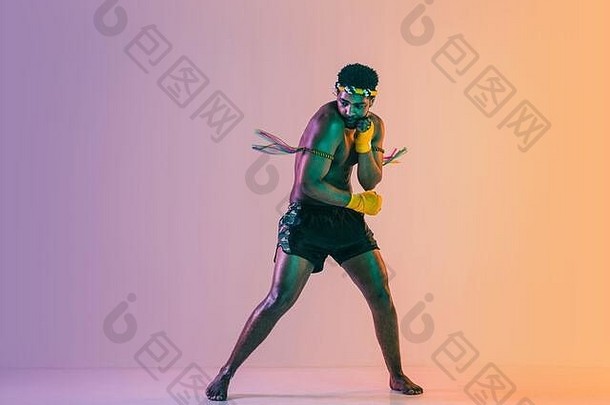 泰拳泰国年轻的男人。锻炼泰国拳击梯度背景霓虹灯光战斗机练习培训武术艺术行动运动健康的生活方式体育运动亚洲文化概念
