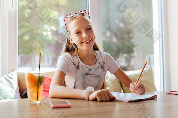 喜气洋洋的黑眼睛女孩画自然坐着咖啡馆