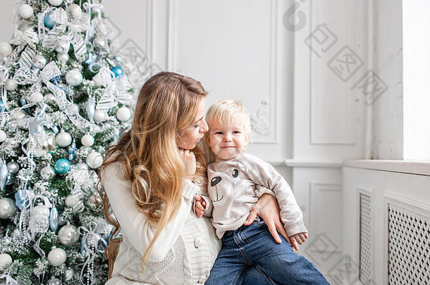 快乐家庭肖像首页年轻的怀孕了妈妈。拥抱儿子快乐一年装饰圣诞节树圣诞节早....明亮的生活房间