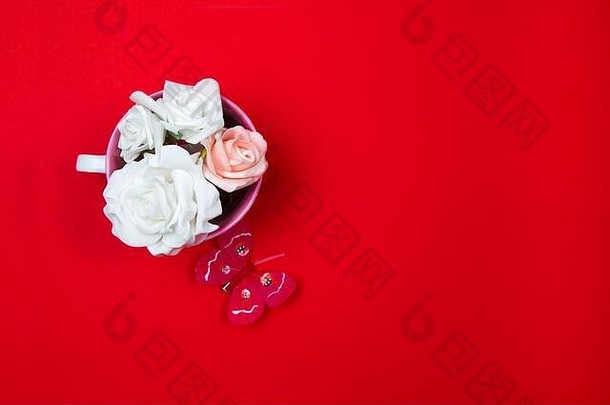 白色玫瑰粉红色的杯红色的背景
