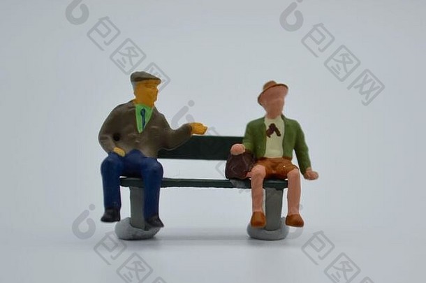 概念科维德社会距离微型雕像坐着公园板凳上工作室拍摄