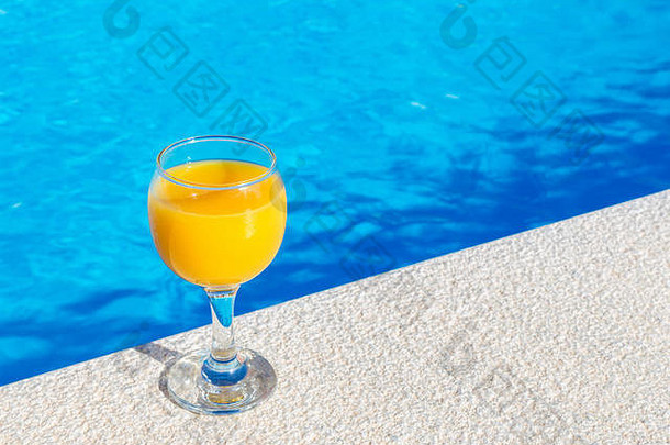 玻璃填满橙色汁站边缘蓝色的游泳池