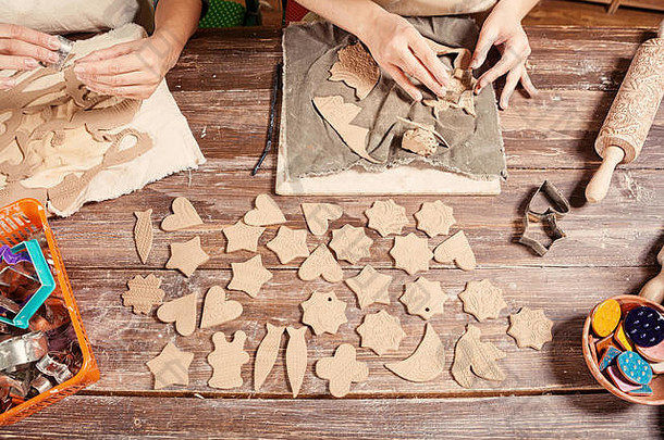 特写镜头女陶工使很多圣诞节玩具形式圣诞节树使棕色（的）粘土形状的心星星熊
