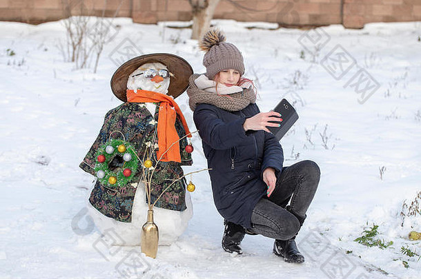 可爱的年轻的女孩采取图片自拍雪人美丽的冬天公园冬天活动孩子们关闭