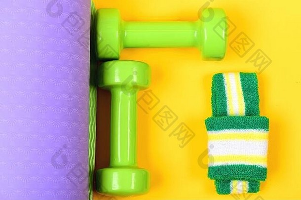 锻炼体育运动概念哑铃使光绿色塑料黄色的紫色的瑜伽席背景前视图塑造健身设备杠铃白色绿色手乐队