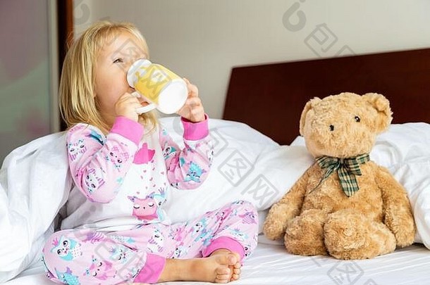 可爱的女孩金发女郎头发坐着床上塞泰迪熊快乐童年保持首页冠状病毒科维德流感大流行