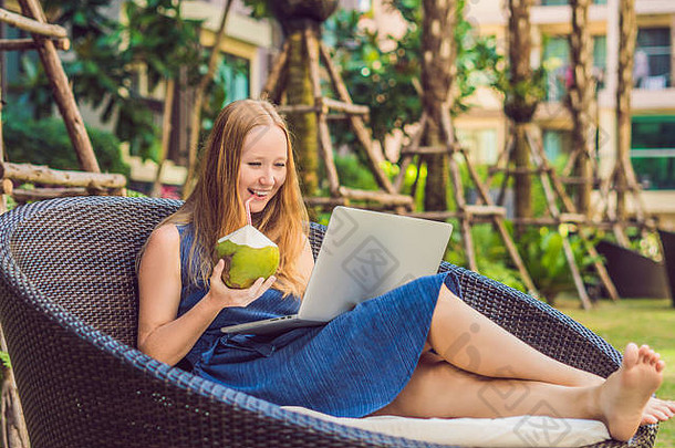 年轻的女自由职业者坐着池移动PC酒店浏览智能手机忙假期遥远的工作概念复制空间文本