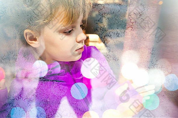 金发碧眼的女孩冻商店窗口玻璃色彩斑斓的模糊灯