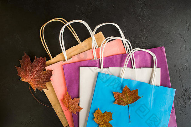 购物色彩斑斓的纸袋Blask背景干叶子平躺